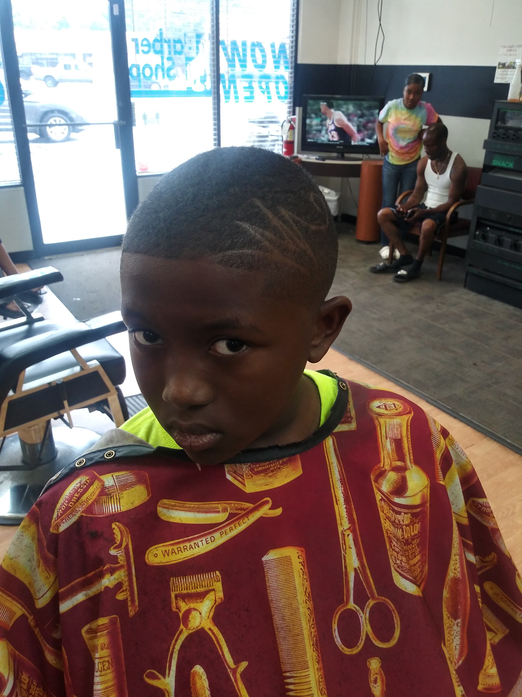 A young client with a design cut into his fade