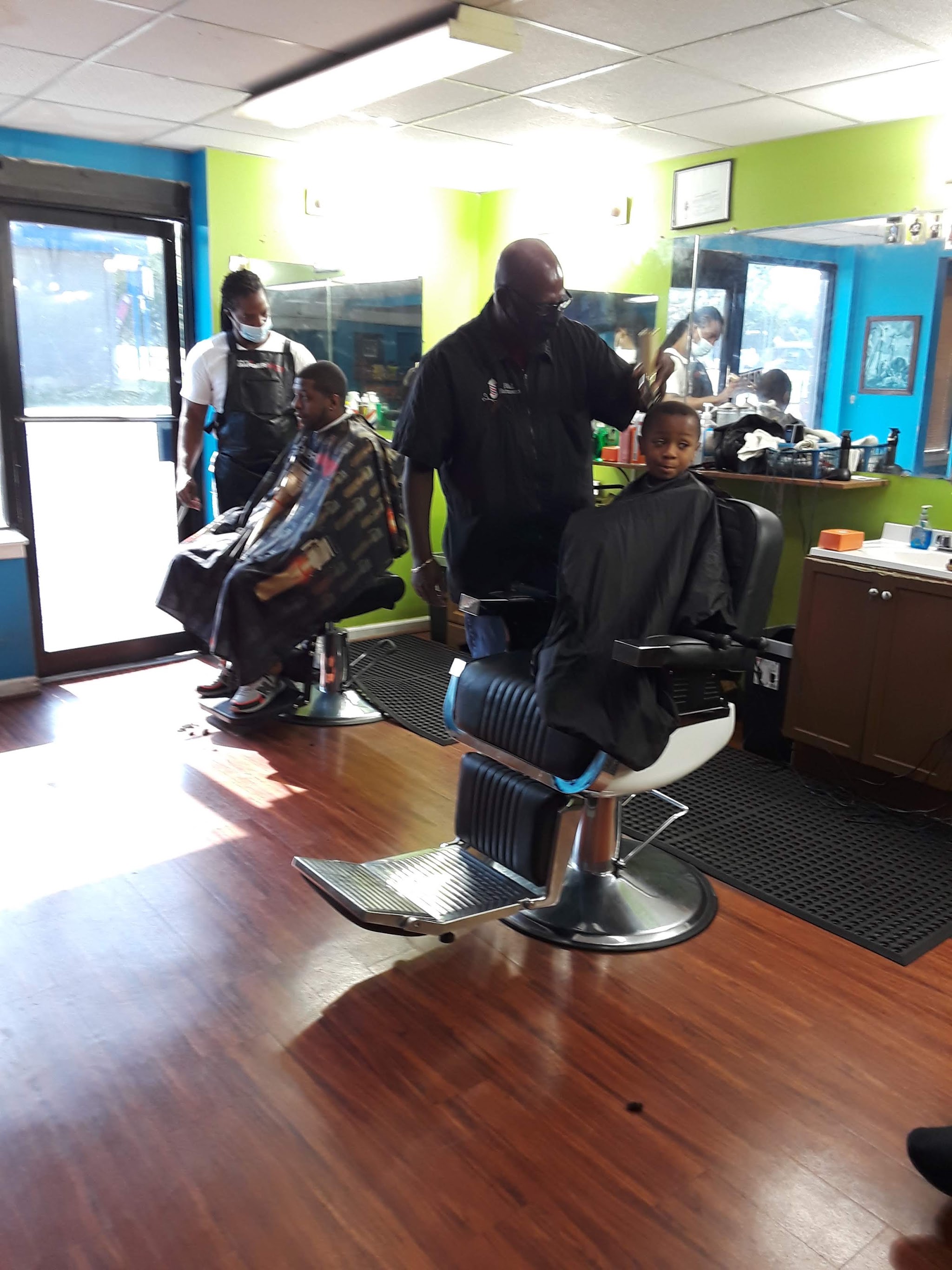 Inside the shop, a barber at work with a young client